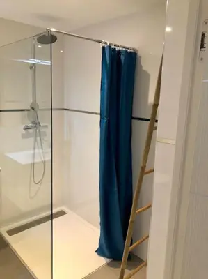 a shower with a blue shower curtain and a ladder at DOMAINE D'ARCA, T2 JARDIN PRIVE/PISCINE/TENNIS in Porto-Vecchio