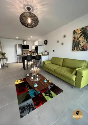 a living room with a green couch and a table at Le Galatée Porticcio in Porticcio