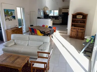 a living room with a white couch and a table at VILLA A SCOPA 14 VUE PANORAMIQUE MER * in Pietrosella