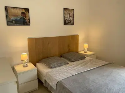 a bedroom with a bed with two night stands and two lamps at VILLA A SCOPA 14 VUE PANORAMIQUE MER * in Pietrosella