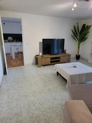 a living room with a flat screen tv on a table at Bas de villa F3 proche Ajaccio in Cuttoli-Corticchiato