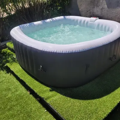 a large hot tub in a yard with grass at Bas de villa F3 proche Ajaccio in Cuttoli-Corticchiato