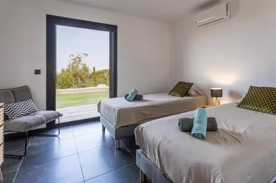 a room with two beds and a couch and a window at Villa Kalinas Corse 4 étoiles in Sari Solenzara