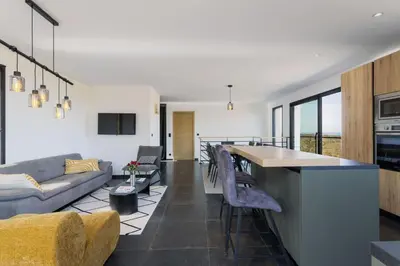 a kitchen and living room with a couch and a table at Villa Kalinas Corse 4 étoiles in Sari Solenzara