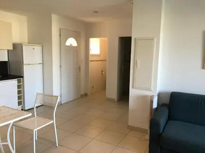 a kitchen and a living room with a couch and a table at punta di buturetu in Propriano