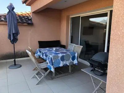 a patio with a table and chairs and a grill at punta di buturetu in Propriano