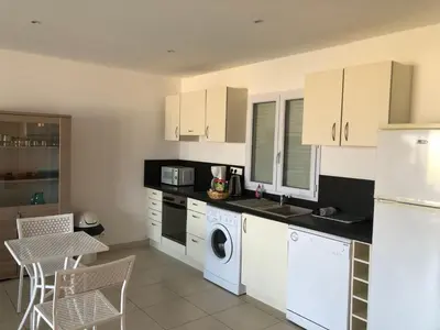 a kitchen with white appliances and a table and chairs at punta di buturetu in Propriano