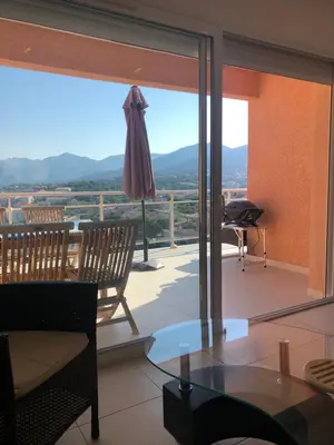 a living room with a view of a balcony at punta di prunetu in Propriano