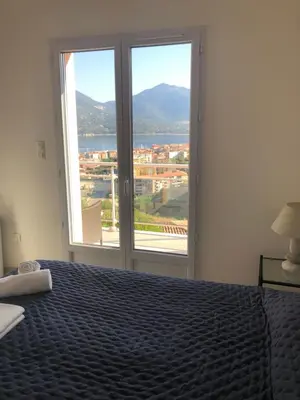 a bedroom with a bed and a large window at punta di prunetu in Propriano