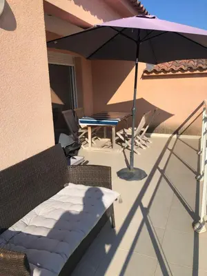 a patio with an umbrella and a table and chairs at punta di prunetu in Propriano