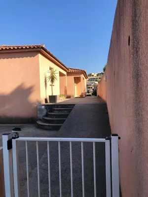 an alley with a white fence next to a building at punta di prunetu in Propriano