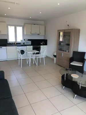 a kitchen and a living room with a table and chairs at punta di prunetu in Propriano