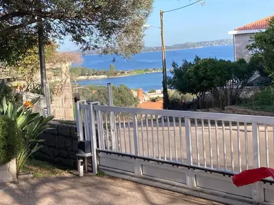 a white fence with a view of the water at Studio à 200m du centre ville de Porto Vecchio,jardin, terrasse parking privé in Porto-Vecchio