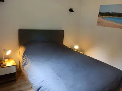 a bed in a bedroom with a blue bedspread at Maison/appartement proche Cala Rossa in Lecci