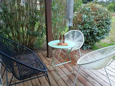 a table and two chairs on a wooden deck at Maison/appartement proche Cala Rossa in Lecci