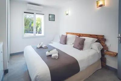 a bedroom with a large bed with two towels on it at Villa La Chiappa Bord de Mer avec piscine chauffée et Jacuzzi in Porto-Vecchio