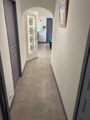a hallway with a tile floor and a door at Villa La Chiappa Bord de Mer avec piscine chauffée et Jacuzzi in Porto-Vecchio