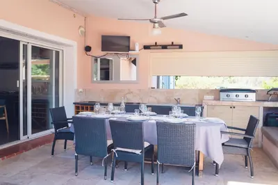 a dining room with a table and chairs at Villa La Chiappa Bord de Mer avec piscine chauffée et Jacuzzi in Porto-Vecchio