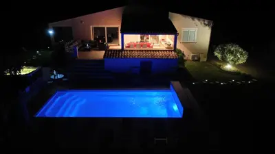 a swimming pool in the yard at night at Villa La Chiappa Bord de Mer avec piscine chauffée et Jacuzzi in Porto-Vecchio