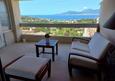 a living room with a table and chairs and a large window at Maison 3 chambres vue Mer in Grosseto-Prugna