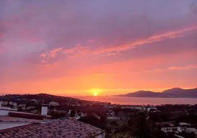a sunset over a city with the sun in the sky at Maison 3 chambres vue Mer in Grosseto-Prugna