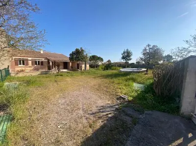 an empty yard next to a house with a fence at Maison de charme en bord de mer in Lucciana