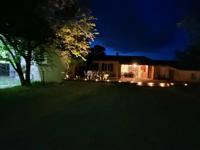 a yard at night with a house with lights at Maison de charme en bord de mer in Lucciana