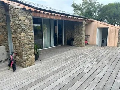 a house with a wooden deck in front of it at Maison de charme en bord de mer in Lucciana