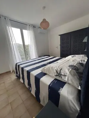 a bedroom with a bed with a blue and white blanket at La Casa San Biaggio in Ajaccio