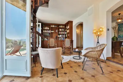 a living room with chairs and a table and bookshelves at La Casa San Biaggio in Ajaccio