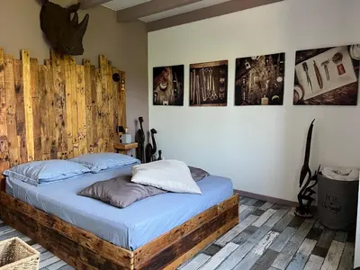 a bed in a room with pictures on the wall at Villa Ponticchio in Santa-Lucia-di-Moriani