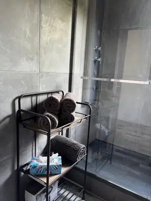 a bathroom with a rack with towels and a shower at Villa Ponticchio in Santa-Lucia-di-Moriani