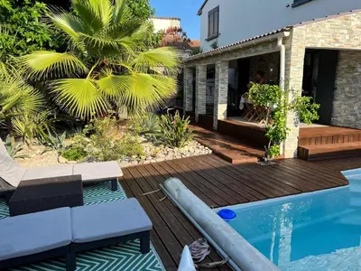 a backyard with a wooden deck and a swimming pool at Villa Ponticchio in Santa-Lucia-di-Moriani