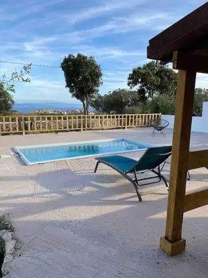 a swimming pool with a bench next to a wooden fence at Grand chalet d’été avec piscine in Bonifacio