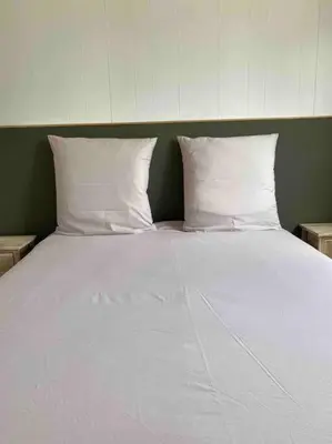 a large white bed with two pillows on it at Grand chalet d’été avec piscine in Bonifacio