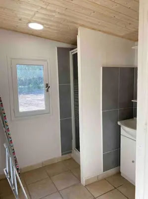 an empty room with a window and a bathroom at Grand chalet d’été avec piscine in Bonifacio