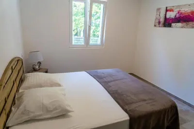 a bed in a white room with a window at A Suara in Ghisonaccia