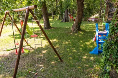 a park with a swing set in the grass at A Suara in Ghisonaccia