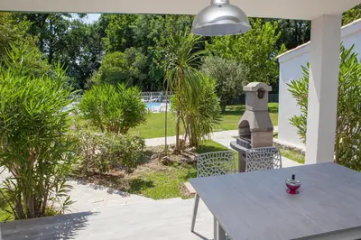 a table and chairs on a patio with a garden at A Suara in Ghisonaccia