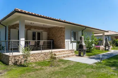 a small house with a porch and a fence at A Suara in Ghisonaccia