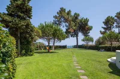 a park with trees and a path in the grass at A Suara Di Mare in Ghisonaccia