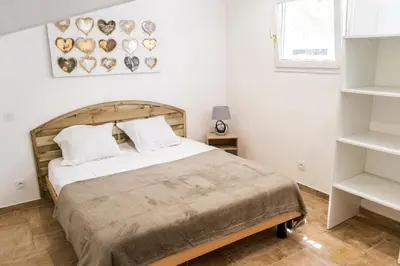 a bedroom with a large bed with a wooden headboard at A Suara Di Mare in Ghisonaccia
