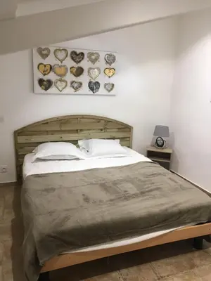 a bedroom with a large bed with a wooden headboard at A Suara Di Mare in Ghisonaccia