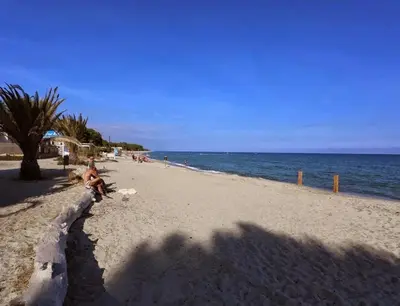 a person sitting on a beach next to the ocean at A Suara Di Mare in Ghisonaccia