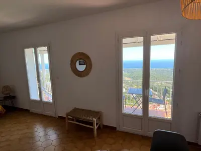a room with two windows and a view of the ocean at Villa tout confort, vue mer exceptionnelle, à Cervione in Cervione