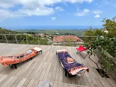 two pillows sitting on top of a wooden deck at Villa tout confort, vue mer exceptionnelle, à Cervione in Cervione