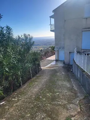 an empty road next to a building with a balcony at Villa tout confort, vue mer exceptionnelle, à Cervione in Cervione