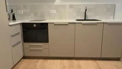 a kitchen with white cabinets and a black oven at Charmant appartement in Ajaccio
