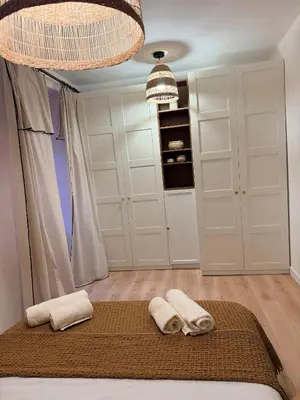 a bedroom with white cabinets and two towels on a bed at Charmant appartement in Ajaccio