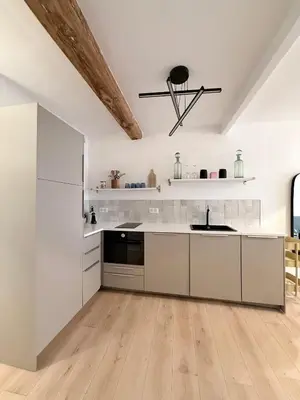 a white kitchen with white cabinets and a sink at Charmant appartement in Ajaccio